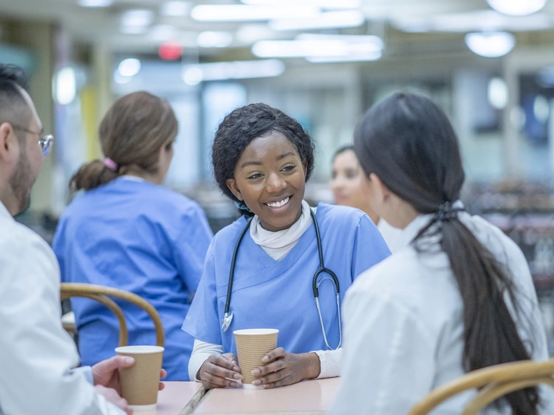 Medical professionals sitting at a table drinking hot beverages
