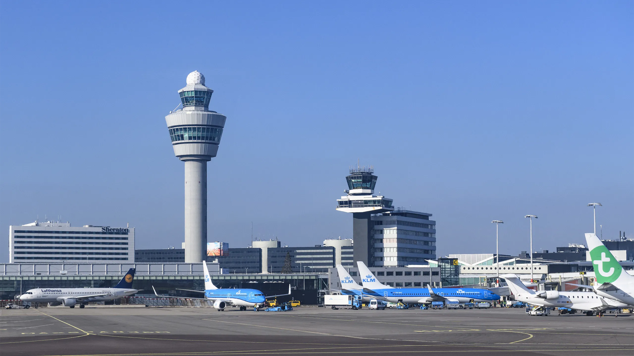 Airplanes at Amsterdam Schiphol Airport in The Netherlands during a springtime sunset.