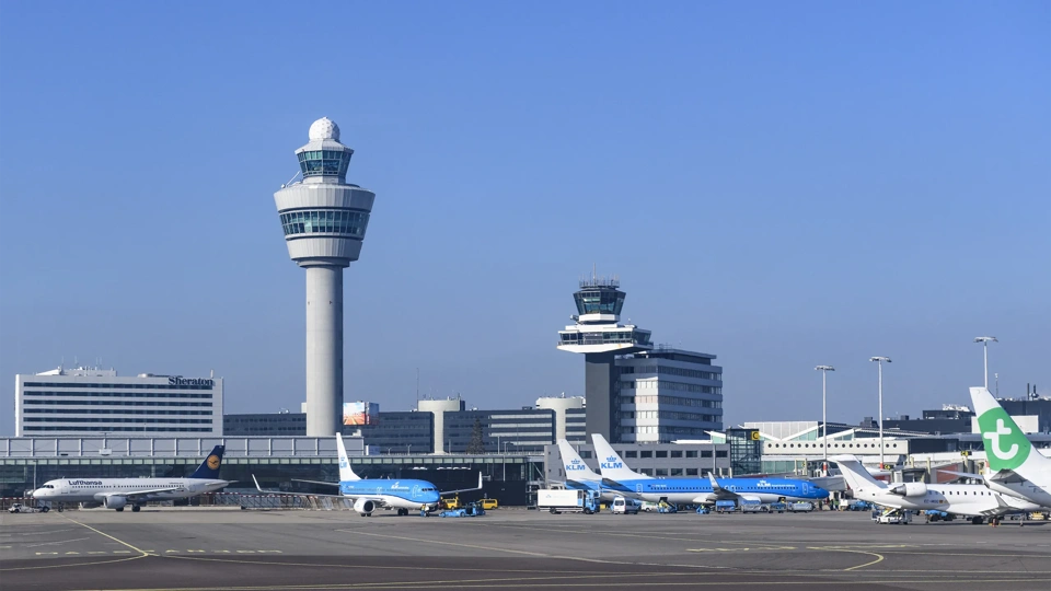 Airplanes at Amsterdam Schiphol Airport in The Netherlands during a springtime sunset.