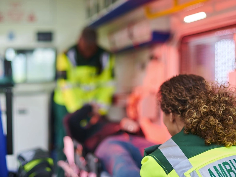Interior of ambulance with two medics professionals and a patient on a stretcher