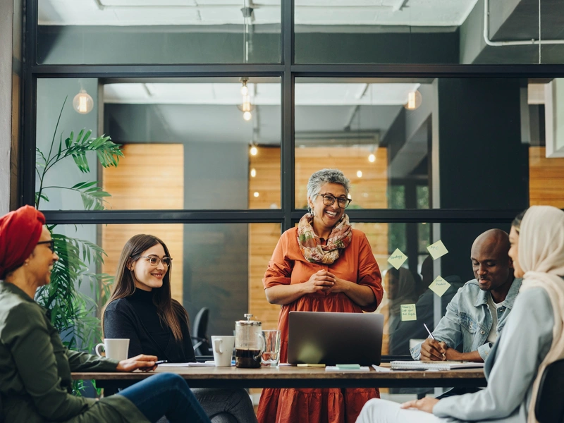 Five professionals sitting around a work desk in a office